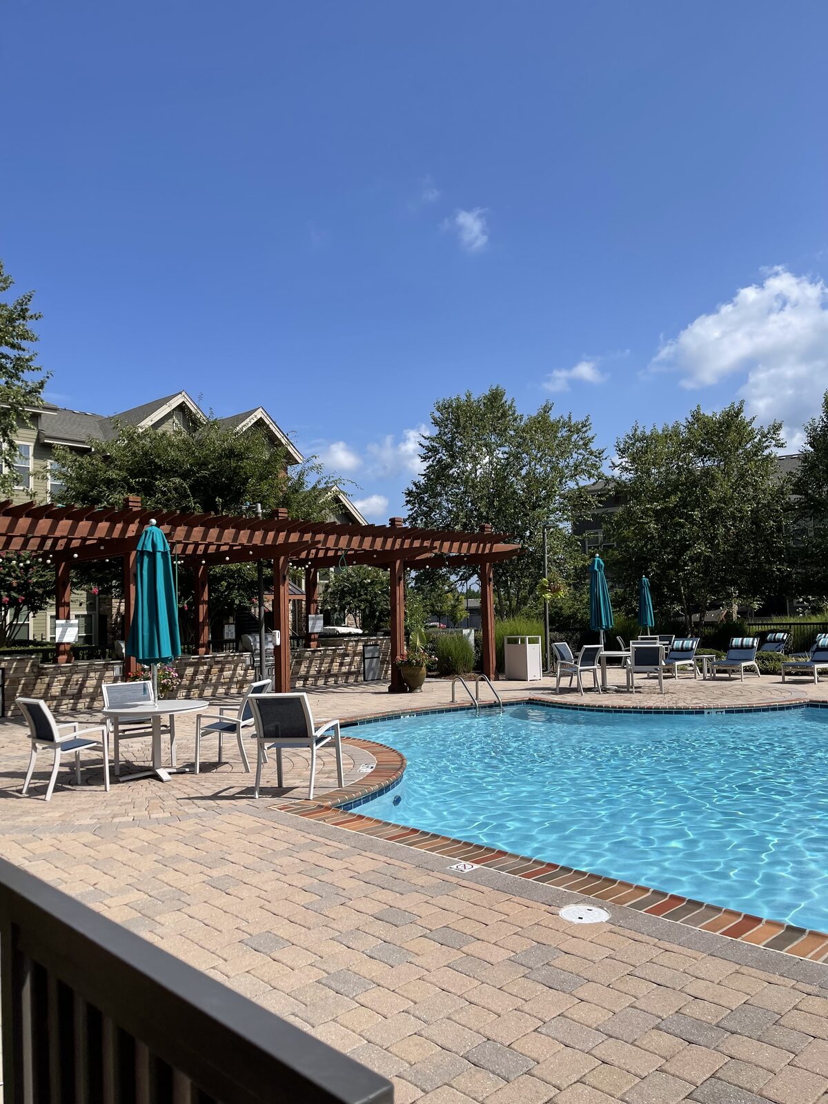 An outdoor pool deck with pergolas at a Convivium Living community