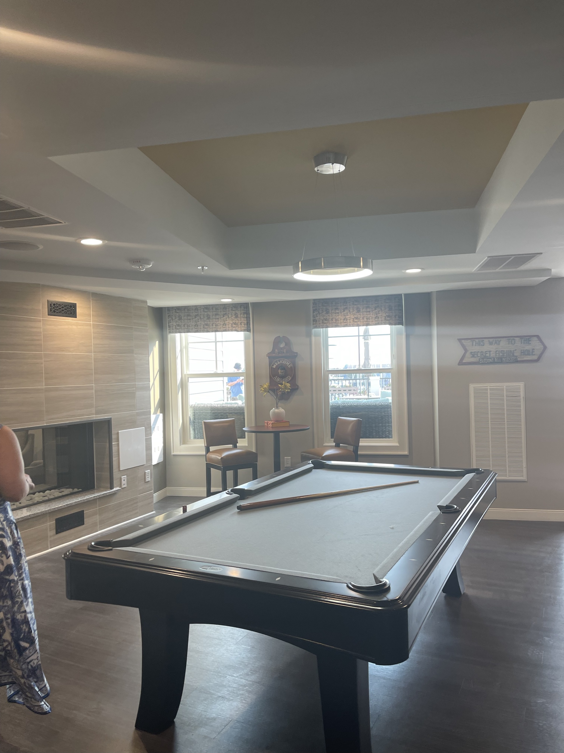 A game room with a pool table in a DanReDev community clubhouse