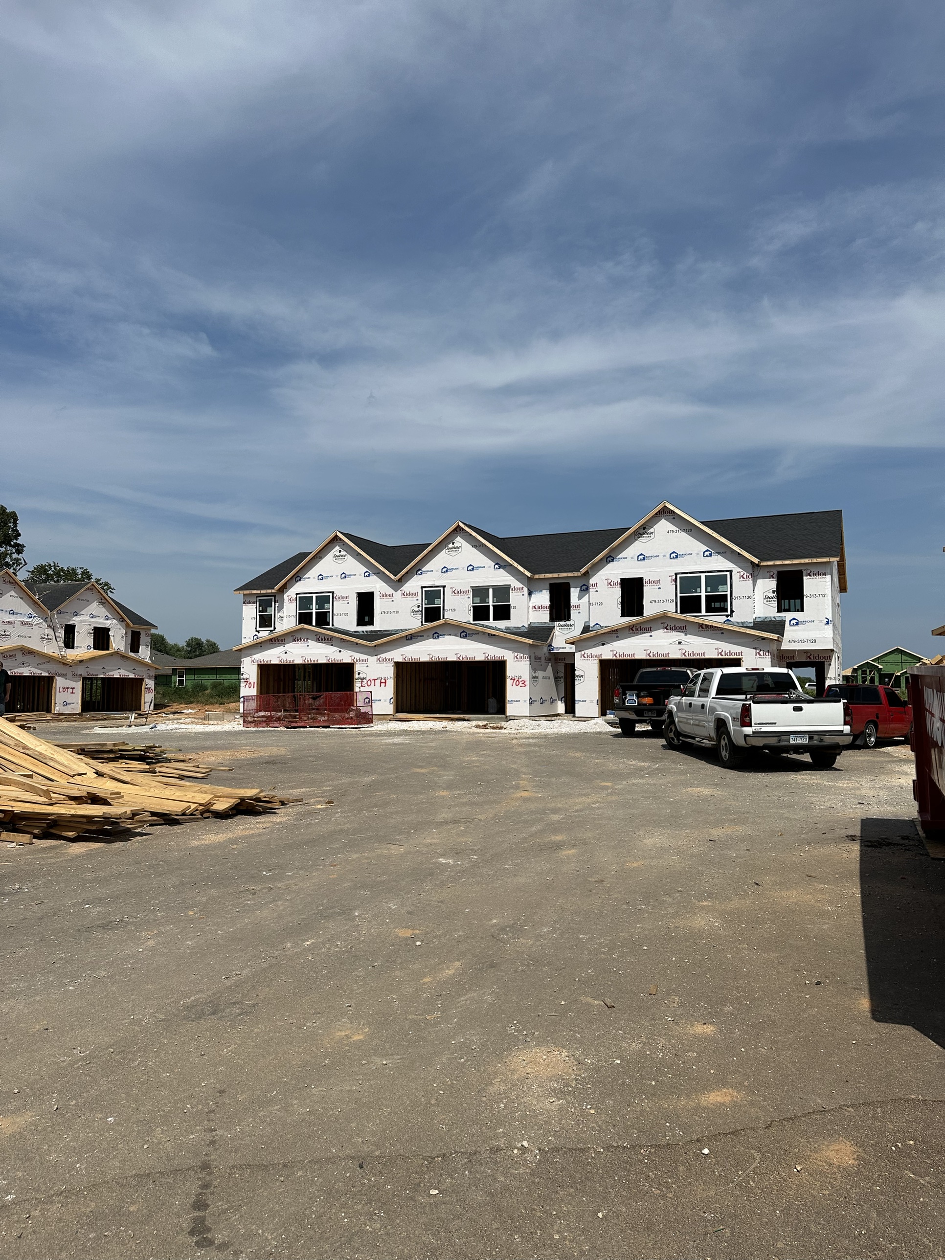 Townhome framing wrapped in branded house-wrap at a DanReDev jobsite