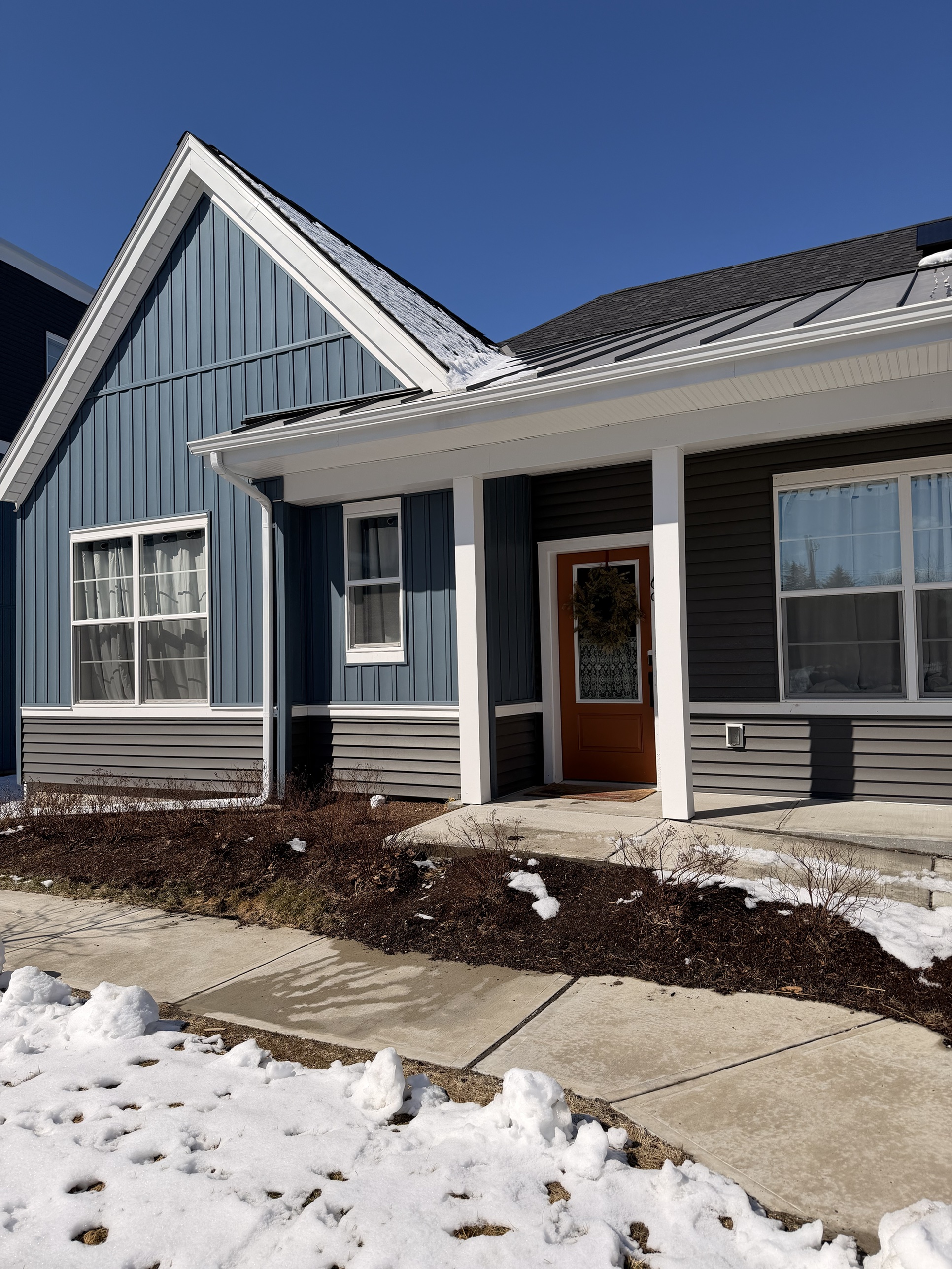Front porch entrance of a Design Build Affordable single-story home in winter