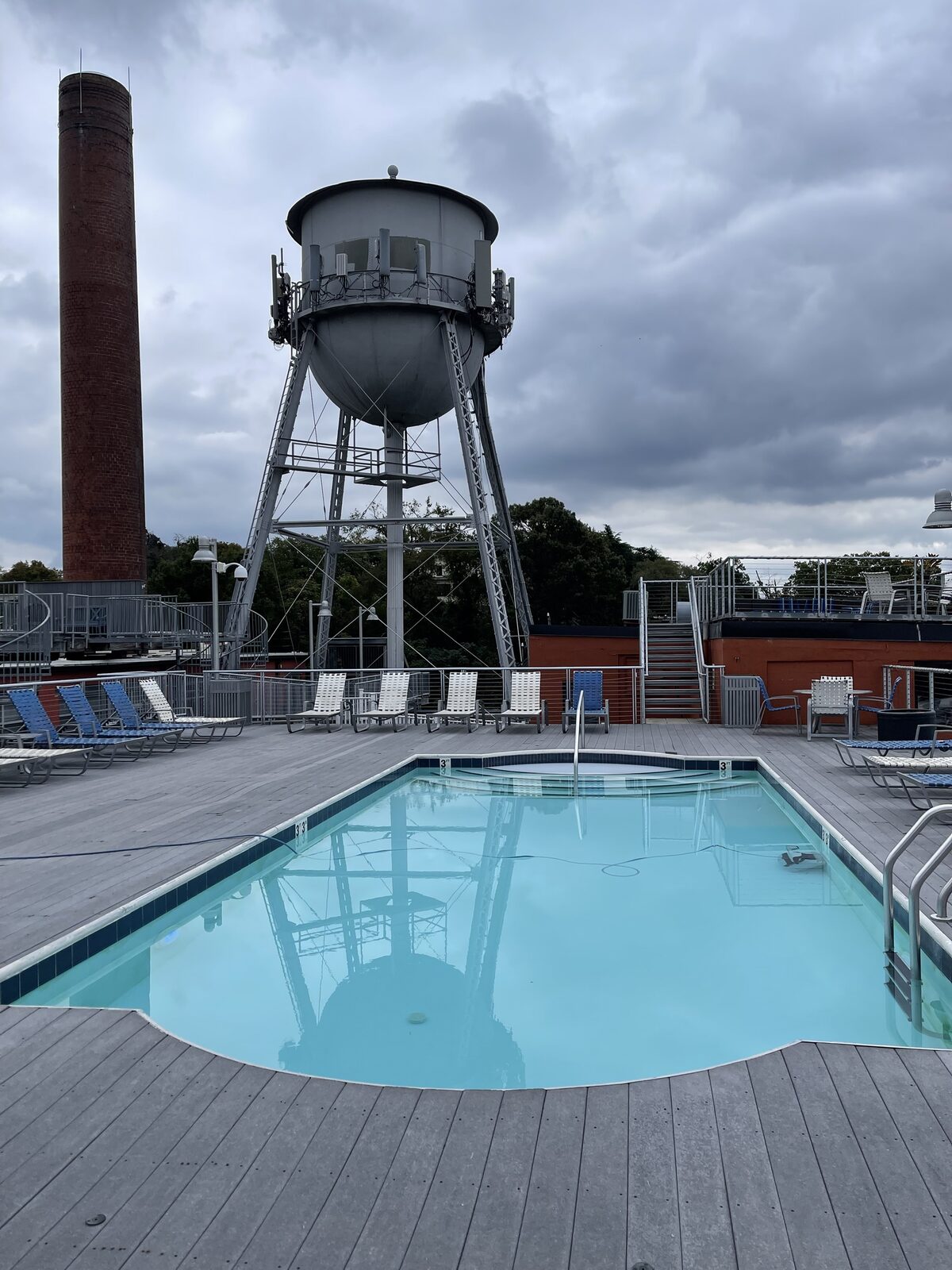 A rooftop pool deck with a restored historic water tower at a Forge Development community