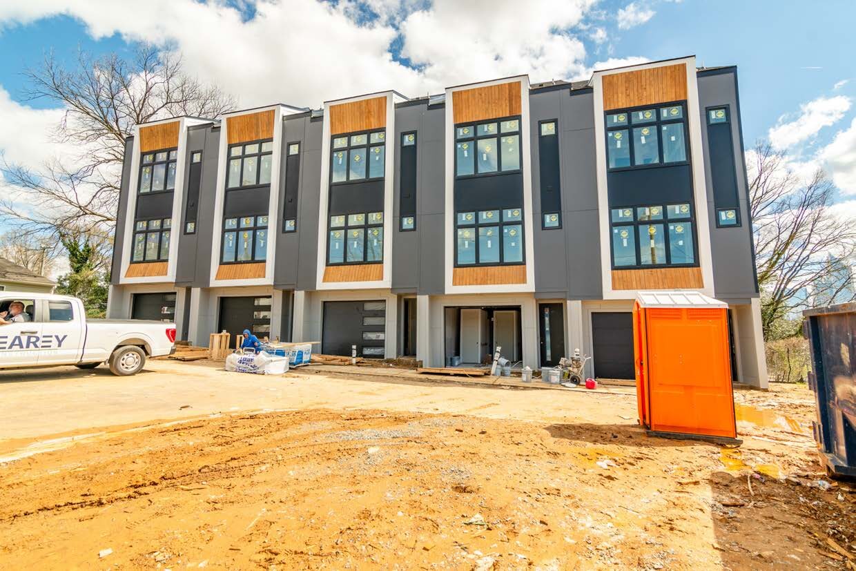 A modern townhome building under construction in an urban infill setting