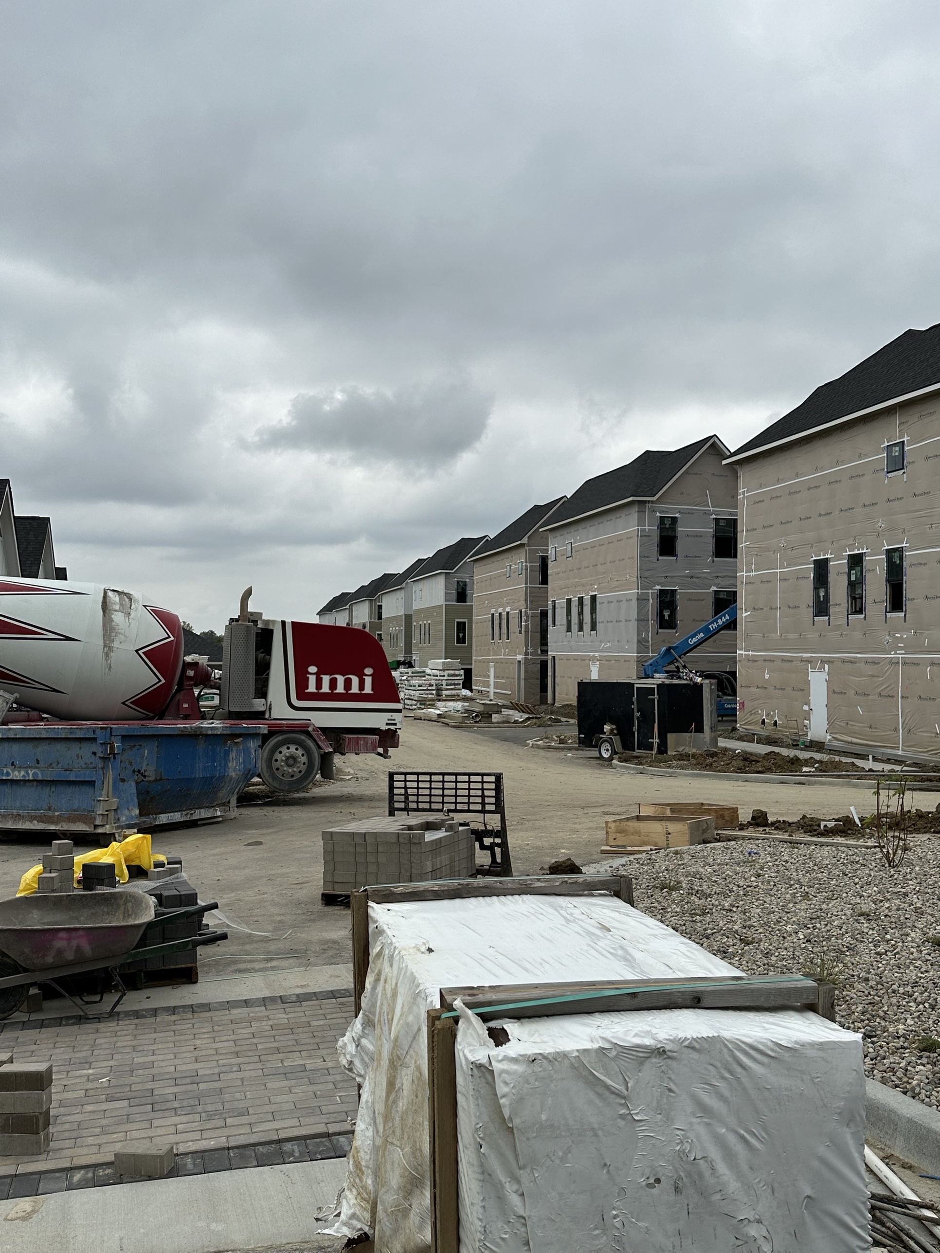 Townhome-style buildings under construction with materials staged on site