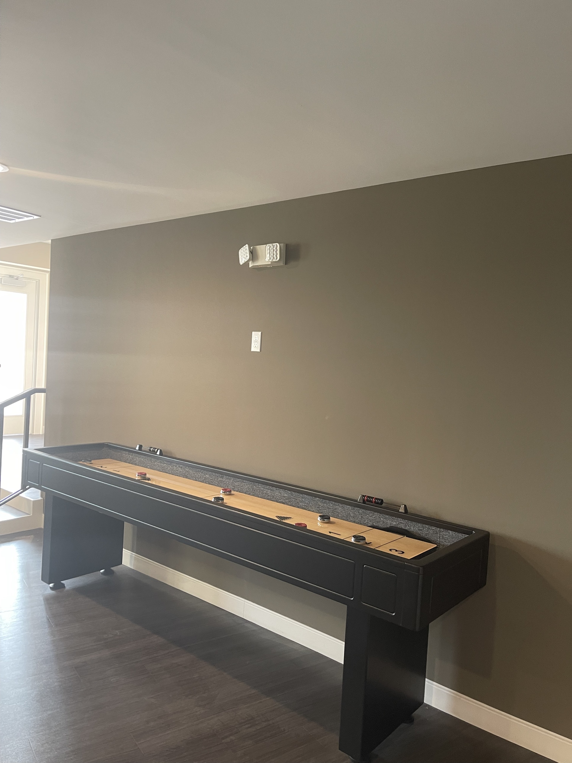 A shuffleboard table in the resident game room