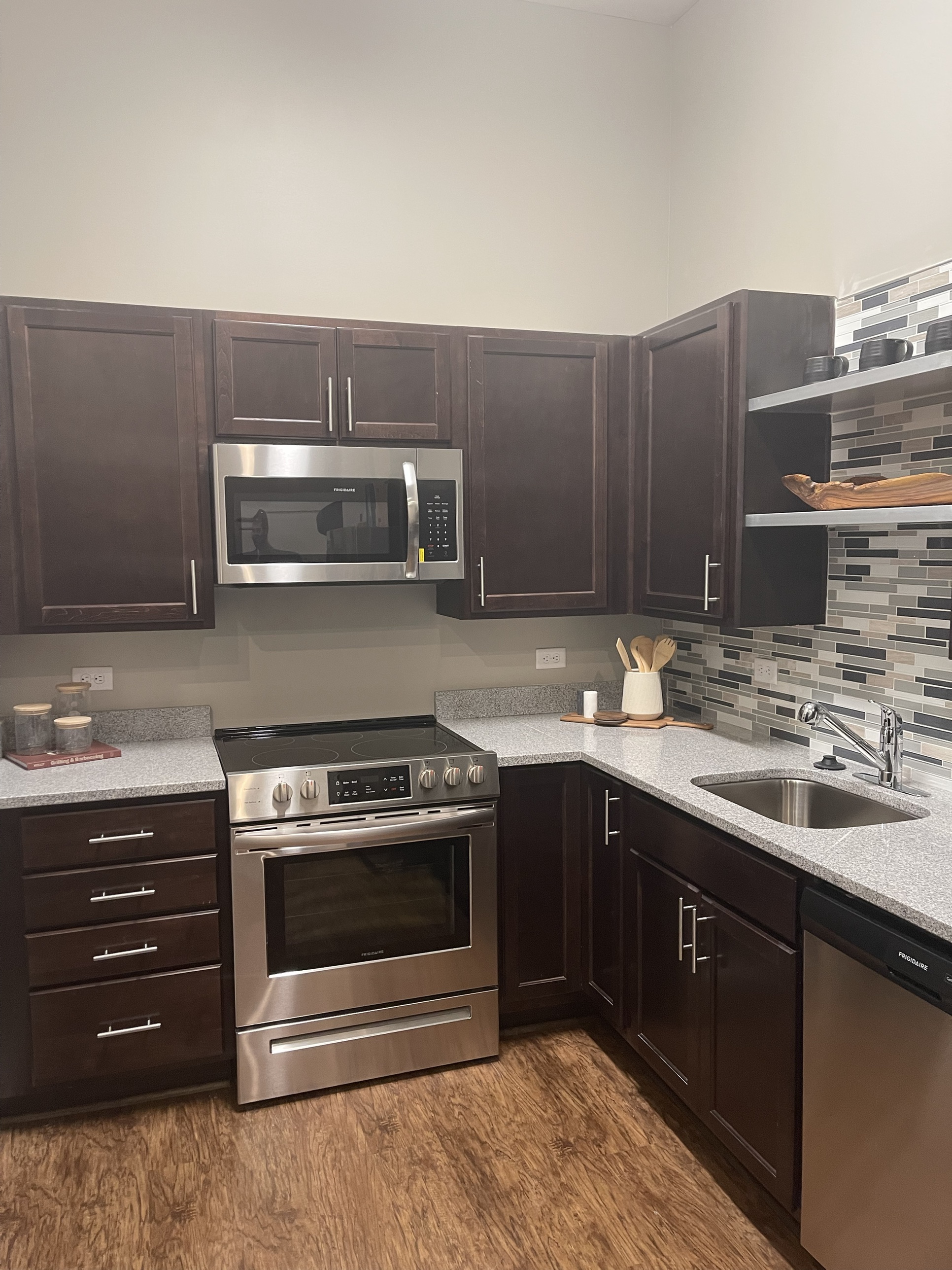 A finished kitchen with stainless steel appliances and a tile backsplash in a completed Greenview Residences unit