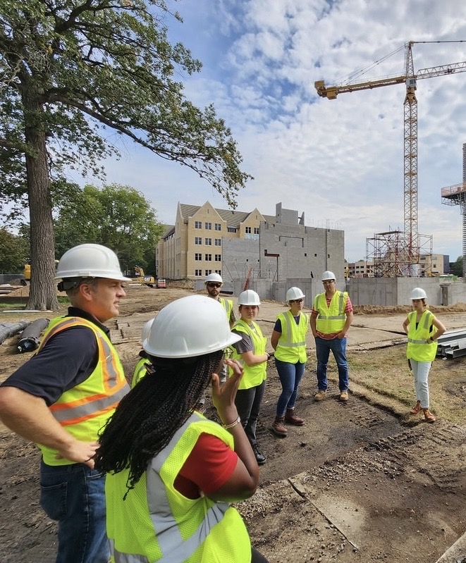 A site walk with a client development team in front of a tower crane