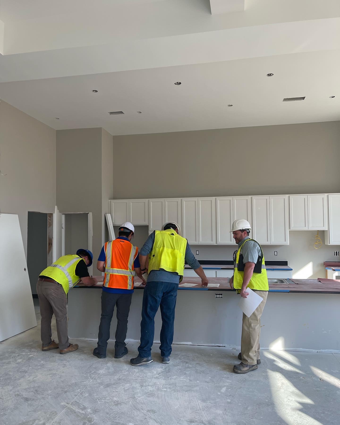 A design review meeting in an unfinished kitchen at a client project