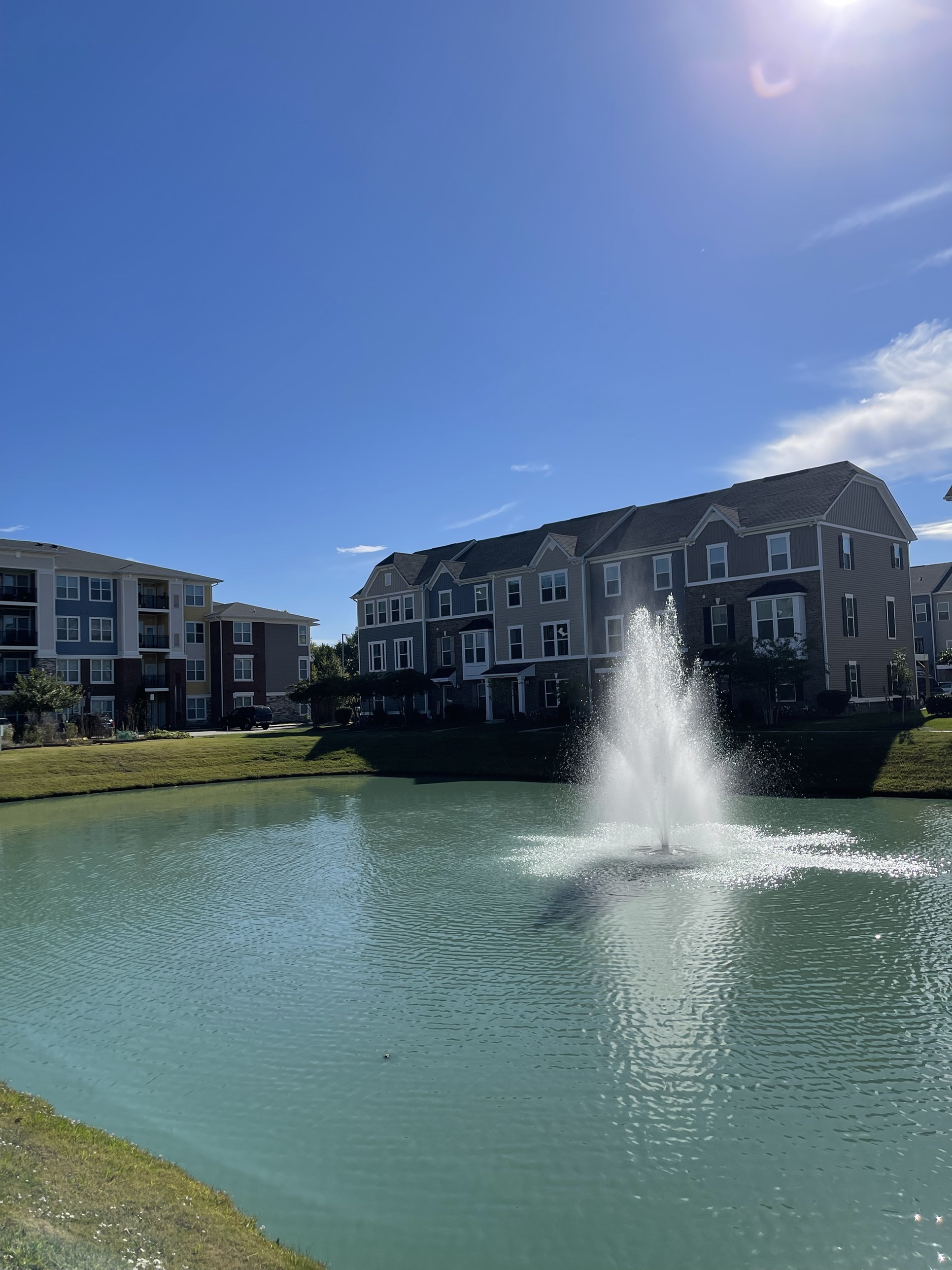 A fountain pond anchoring the townhomes beyond, the kind of centerpiece that turns a development into a destination