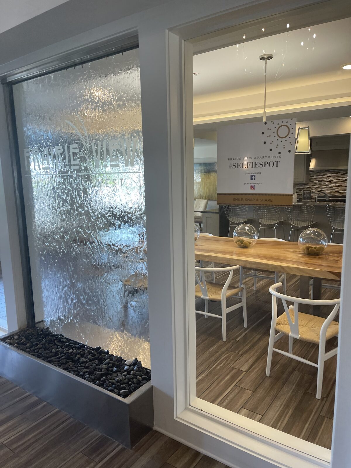 A glass water feature and signage at a Kaufman Development community