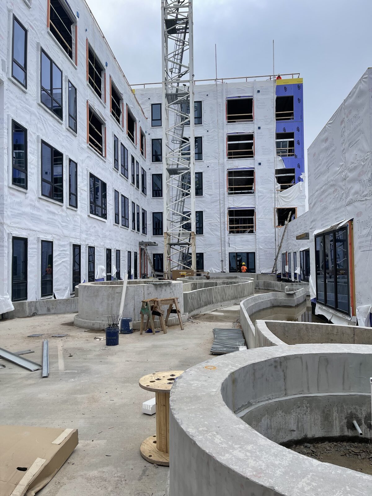 A mid-rise building under construction with a tower crane