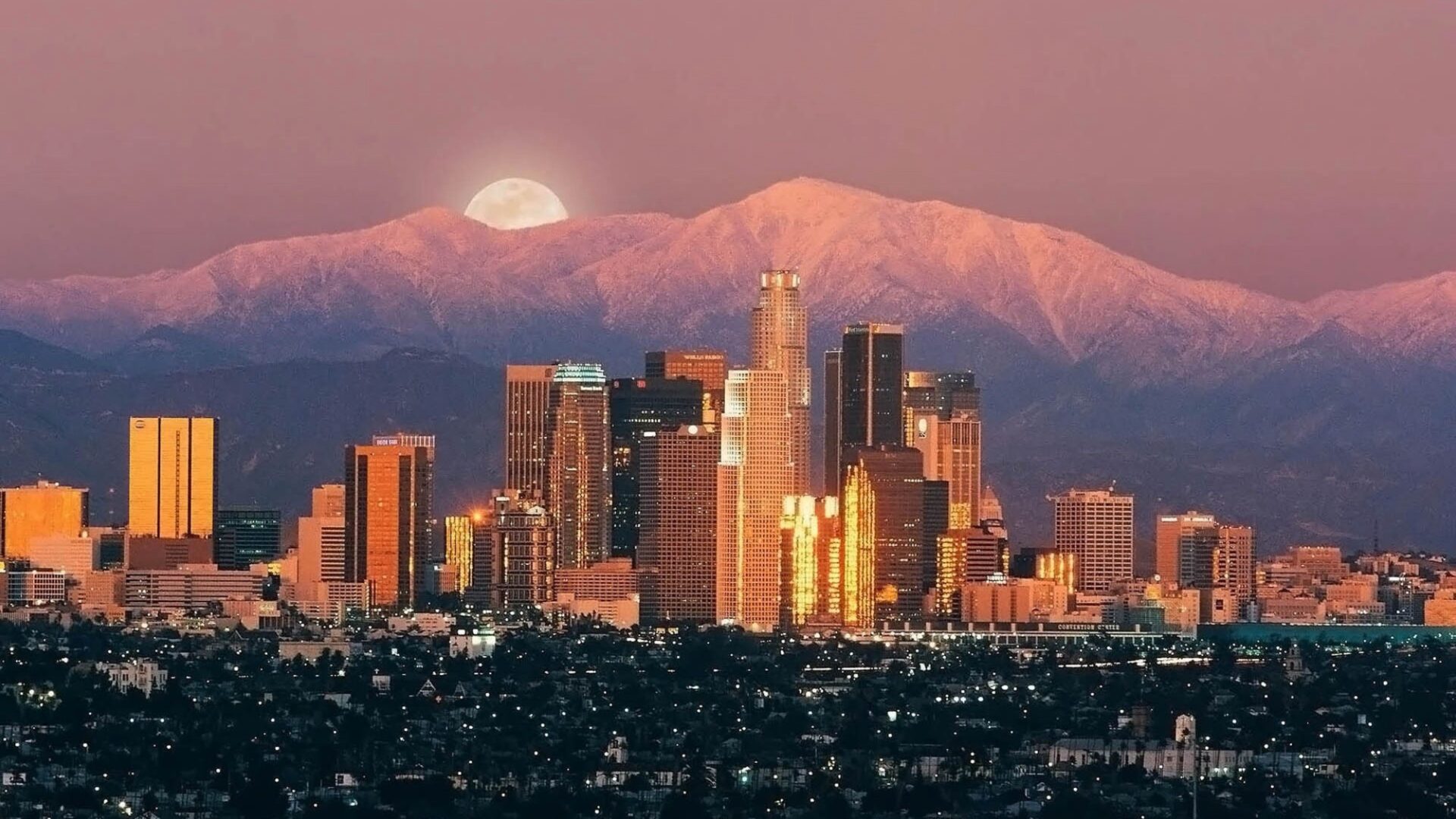 Snow-capped mountains behind urban skyline